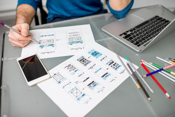 UX designer working on the mobile application experience sketching drawings at the office. Image focused no the drawsings cropped with no face