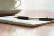 © Елена Николаева - blank white notebook, pen and cup of coffee on the desk