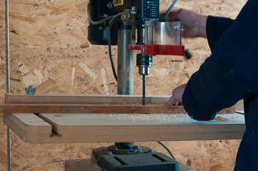 Sticker - Carpenter working on the drill press in the small workshop.