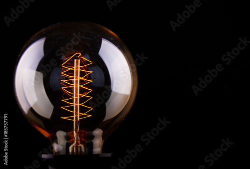 Cuadros en Lienzo classic Edison light bulb on black background