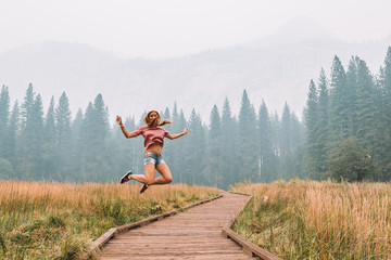 Young girl exploring Yosemite National Park near California by lakes forests and mountains 