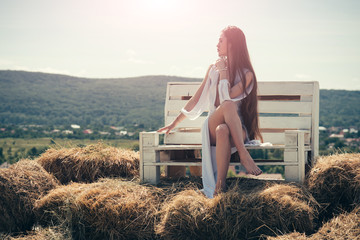 Wall Mural - Girl in sexy dress sit on wooden bench