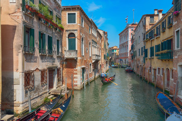 Wall Mural - Traditional narrow canal street with gondolas and old houses in Venice, Italy. Architecture and landmarks of Venice. Beautiful Venice postcard.