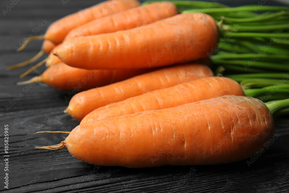 Tasty ripe carrots on wooden background