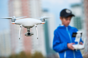 Wall Mural - young man operating of flying drone at sunset