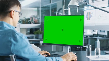 Aufkleber - Automotive Engineer Working on a Personal Computer With Isolated Mock-up Green Screen on it. Shot on RED EPIC-W 8K Helium Cinema Camera.