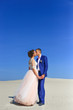 Young wedding couple on beautiful sand dune with wives on sea 