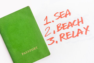 Wall Mural - Green passport next to the list Sea, Beach, Relax written in orange marker