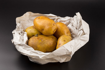 Wall Mural - Uncooked fresh potatoes isolated on a Black background