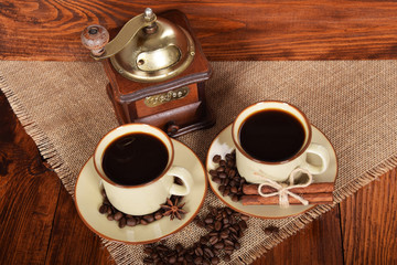 two cups of black coffee next to a coffee grinder with free space for text