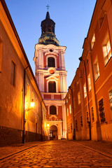 Wall Mural - Cobbled street and baroque tower of the former monastery in the evening in Poznan.