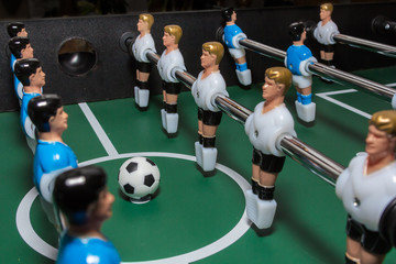 Soccer table game. Green field with blue and white plastic footballers