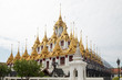 Golden Spires Against Cloudy Sky at Loha Prasart Buddhist temple complex