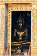 Large Golden Buddha Statue Seen Through Doorway at Loha Prasart temple complex in Bangkok
