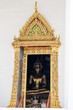 Large Golden Buddha Statue Seen Through Ornate Doorway at Loha Prasart temple complex in Bangkok