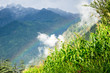 A Rainbow Appears Over Corn Stalks and Clouds with the Himalayas Behind