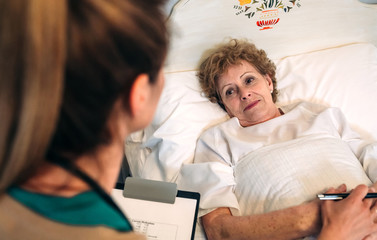 Wall Mural - Young female doctor comforting older female patient