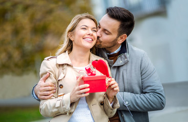 Couple in love.Man surprising his girlfriend with a gift on Valentine's Day