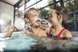 © Westend61 - Happy father with daughter splashing in indoor swimming pool