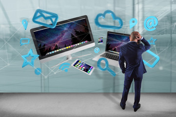 Wall Mural - Businessman in front of a wall with Devices like smartphone, tablet or computer flying over connection network and app- 3d render