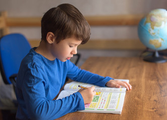 Little boy solving mathematics exercise homework