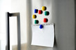 Blank paper sheet with magnets on refrigerator door