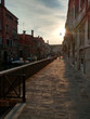 Venice street aside the canal with pavement at sunset in Italy