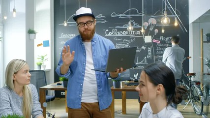 Poster - Creative Project Manager Holds Laptop and Talks to Talented Young Developers at the Team Meeting, They Discuss, Aims, Goals and Ambitions. Stylish Business Office. 