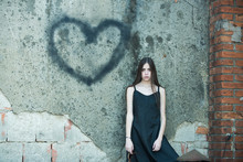 Girl Posing With Heart Graffiti On Grey Wall