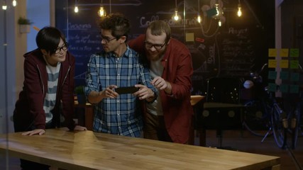 Poster - Great Concept For Augmented Reality Mock-up. Three Young Developers Look at Augmented Reality Through Smarthpone. They're Working on the New Virtual Reality Game. 