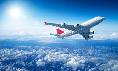 Wall Mural - airplane flying above clouds