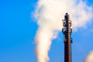 Power plant smokestack with carbon emission - co2, dioxide or fossil fuel. Air pollution by industry. Chimney and smoke cloud on blue sky background.