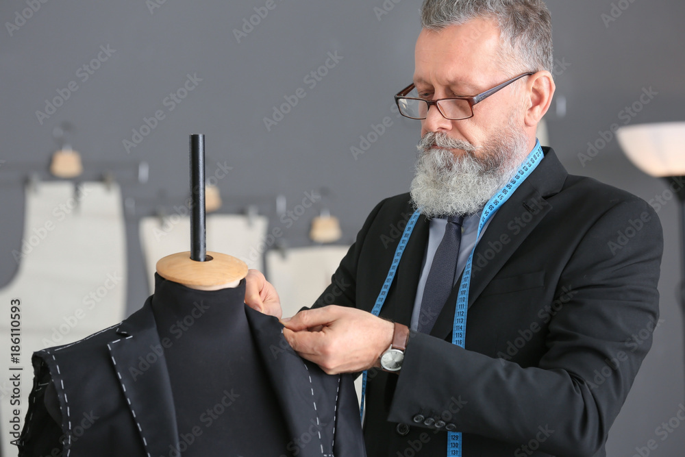 Senior man tailoring formal suit in atelier