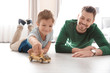 © Africa Studio - Cute little boy and father playing with toy car on floor at home