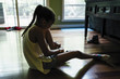 © Inti St. Clair - Girl sitting on floor putting on shoes