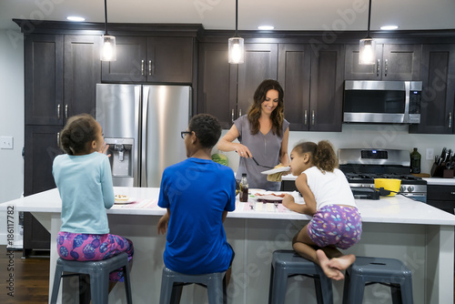 Fotografie, Obraz Mom cooking breakfast for kids in kitchen