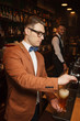 © Tkachenko Alexey - The barman in a suit pours beer