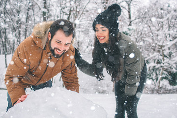 happy young couple in winter . family outdoors. man and woman looking upwards and laughing. love, fu