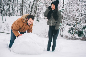 happy young couple in winter . family outdoors. man and woman looking upwards and laughing. love, fu