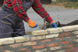 © sima - Worker building brick wall using hammer tool