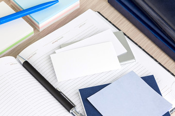 Wall Mural - Open blank notepad and pen with blank bussinesscard on a desk of a bussinessman