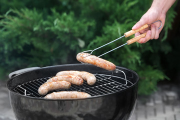 Sticker - Man preparing delicious sausages on barbecue grill outdoors