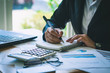 © kanyarat - Business man working with document graph. Business man are analyzing business documents. Busness man working at the co-working space.