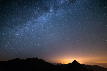 Wall Mural - the wonderful starry sky on christmas time and the majestic high mountain range of the italian alps,
