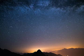 Wall Mural - the wonderful starry sky on christmas time and the majestic high mountain range of the italian alps,