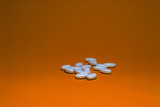 Fototapeta  - Tablets with calcium on a orange background. White pills on a colored background.