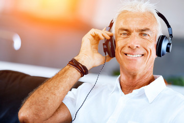 Wall Mural - Handsome gray haired senior man with headphones