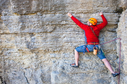 Fotomural Climber in a helmet climbs up.