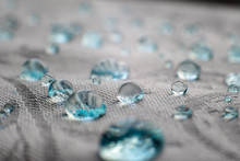 Blue Drops On Water Repel Textile Fabric Fibers. Close-up Macro