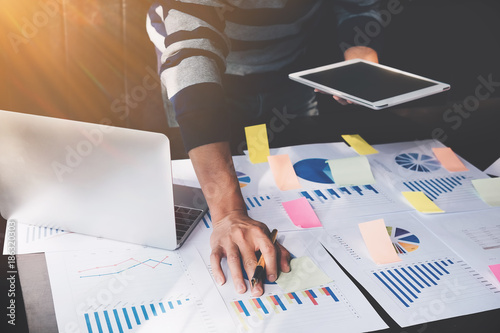 Plakaty do biura rachunkowego business-man-holding-digital-tablet-and-use-laptop-to-working-document-accountant-analyze-income-budget-tax-is-are-planning-a-marketing-plan-to-improve-the-quality-of-their-sales-in-the-future